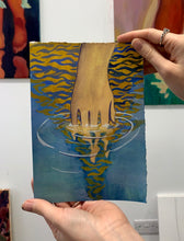 Load image into Gallery viewer, Hand dissolving in blue and yellow