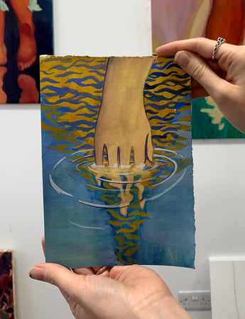 Hand dissolving in blue and yellow