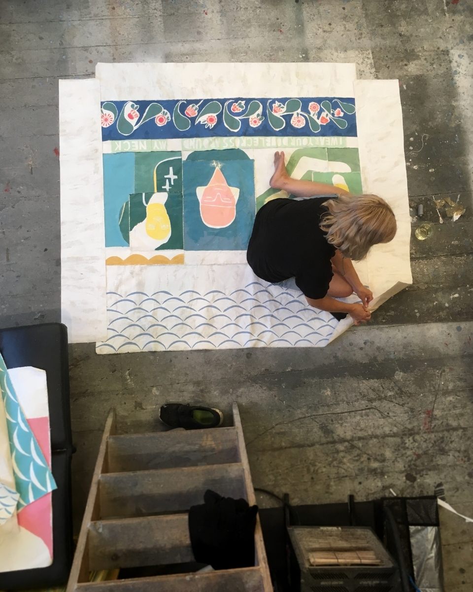 High-angle above shot of artist Ali Bassett working on a textile artwork in her studio for Partnership Editions.