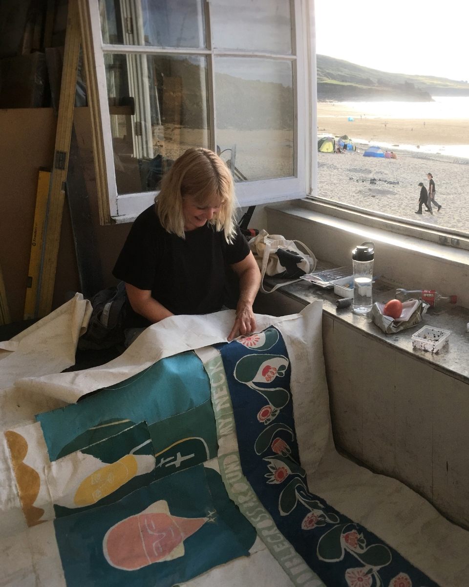 Carousel image of artist Ali Bassett stitching one of her contemporary textile pieces together in her studio for Partnership Editions.
