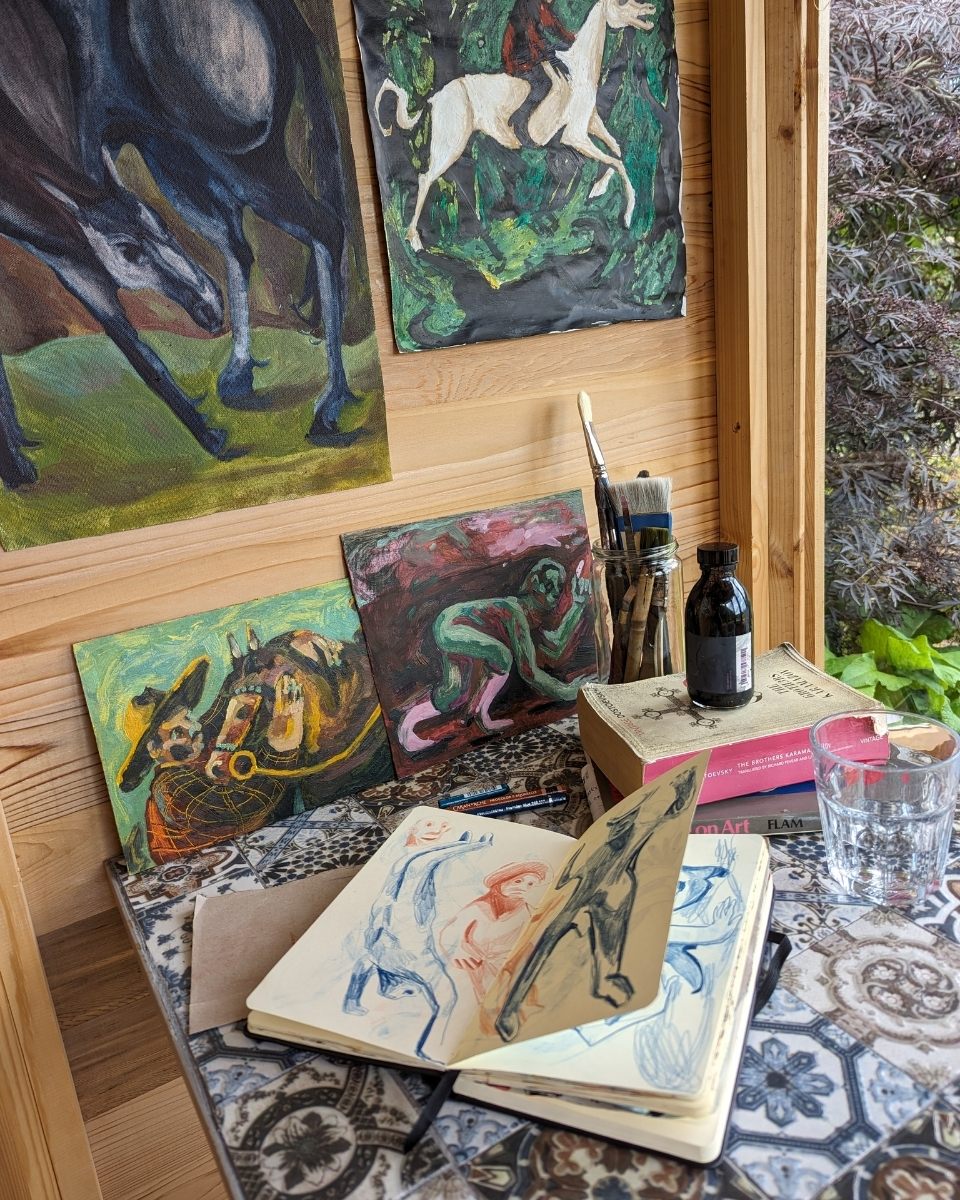 Detail shot of Alice Carr’s artist studio featuring her sketchbook, contemporary prints, and paints for Partnership Editions.