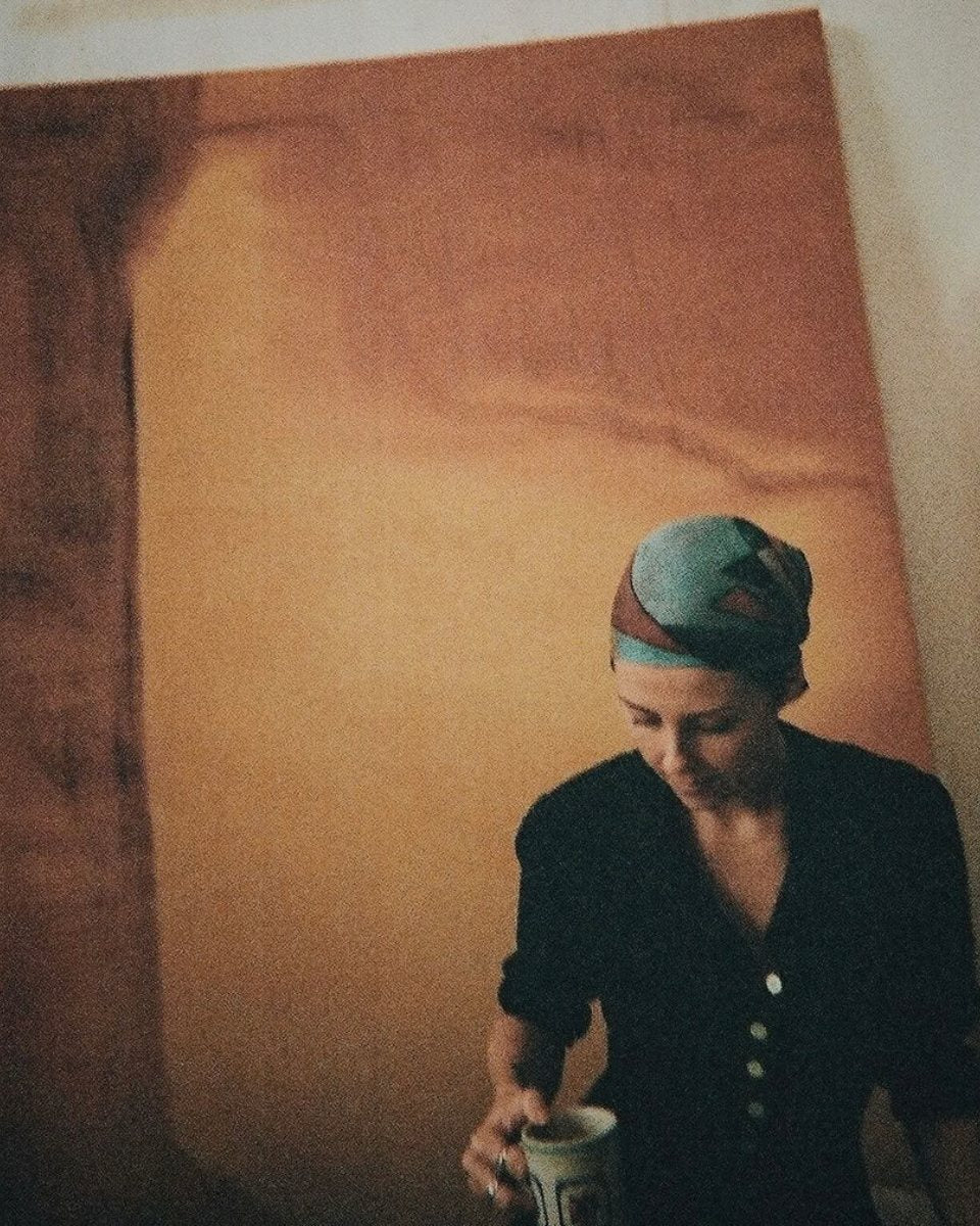 Portrait image of artist Alina Welch in her studio captured in front of a large-scale contemporary painting for Partnership Editions.