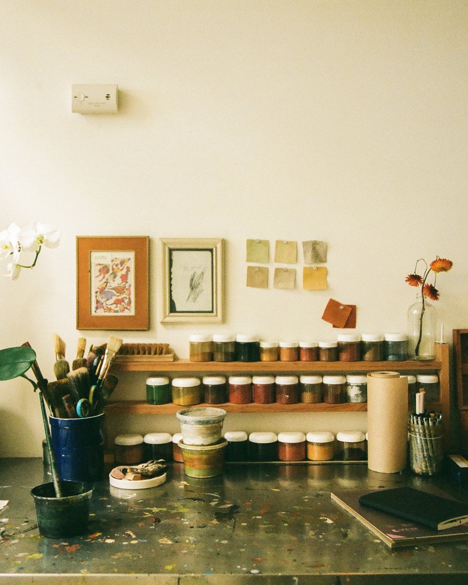 Studio shot featuring raw pigments, artist brushes, and painting materials used by Alina Welch for her contemporary artworks at Partnership Editions.