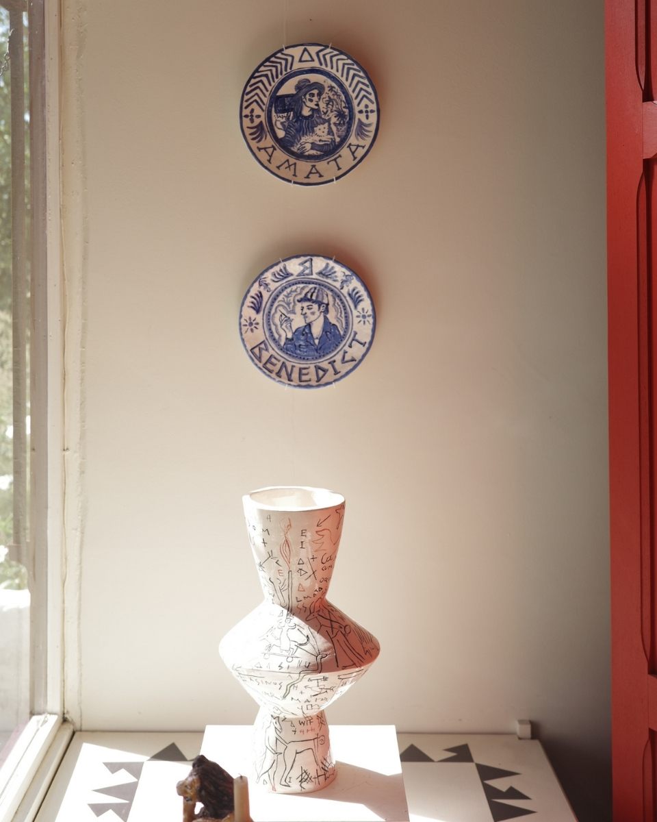Carousel studio image featuring a sculptural vase and decorative plates by Amata Benedict mounted on a wall for Partnership Editions.