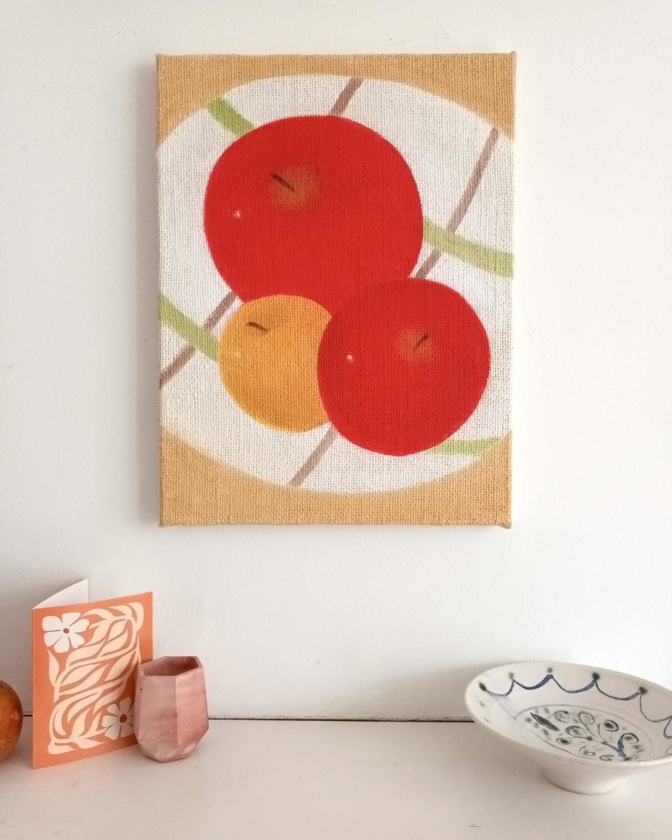 Brendan Lancaster’s contemporary oil painting of an apple, mounted and displayed on a wall for Partnership Editions.
