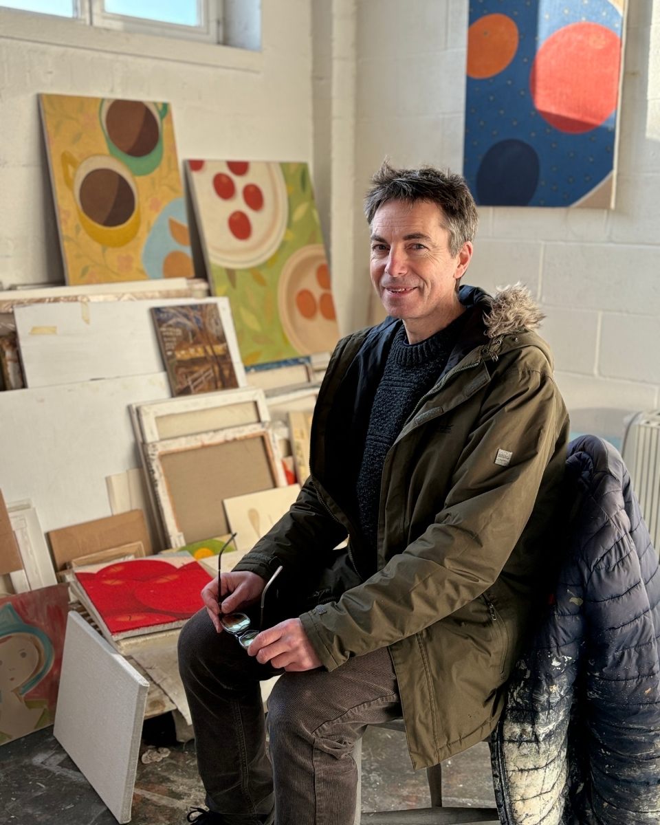 Portrait of artist Brendan Lancaster in his studio surrounded by contemporary paintings and canvases for Partnership Editions.
