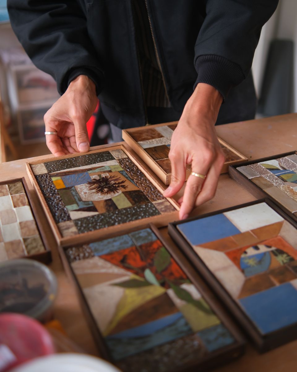 Daniel Dzonu-Clarke placing a framed artwork on his studio worktable for Partnership Editions.
