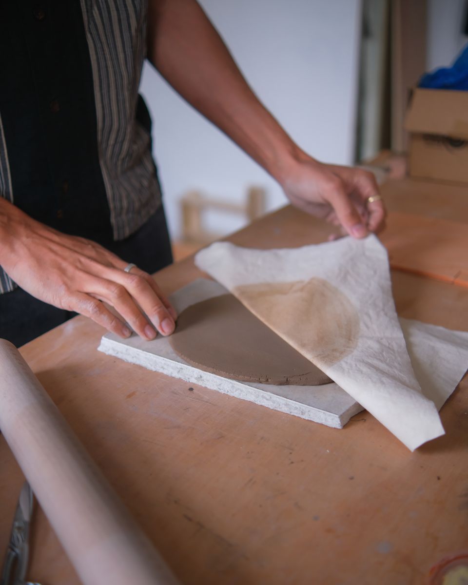 Daniel Dzonu-Clarke uncovering clay base layers in his creative studio for Partnership Editions.