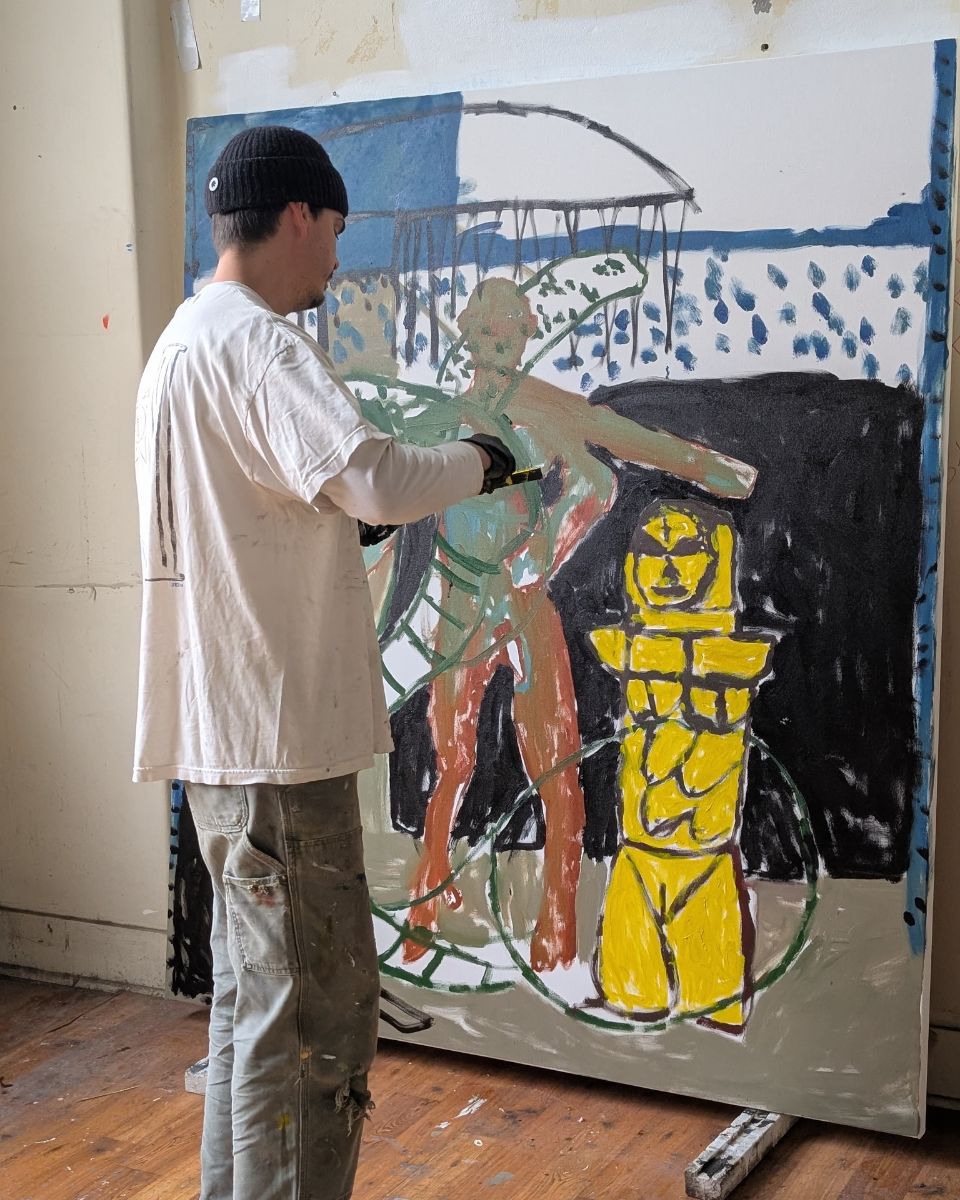 Artist Darcy McCrae working on a large-scale contemporary canvas painting inside his studio.
