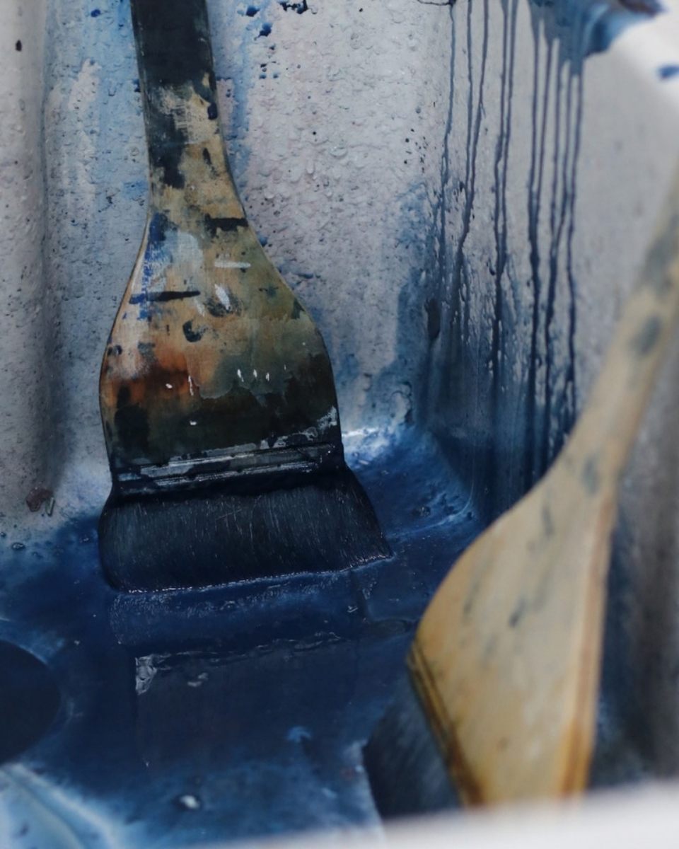 Close-up detail of blue stained paintbrushes in David Hardy’s artist studio, showcasing his limited colour palette for Partnership Editions.