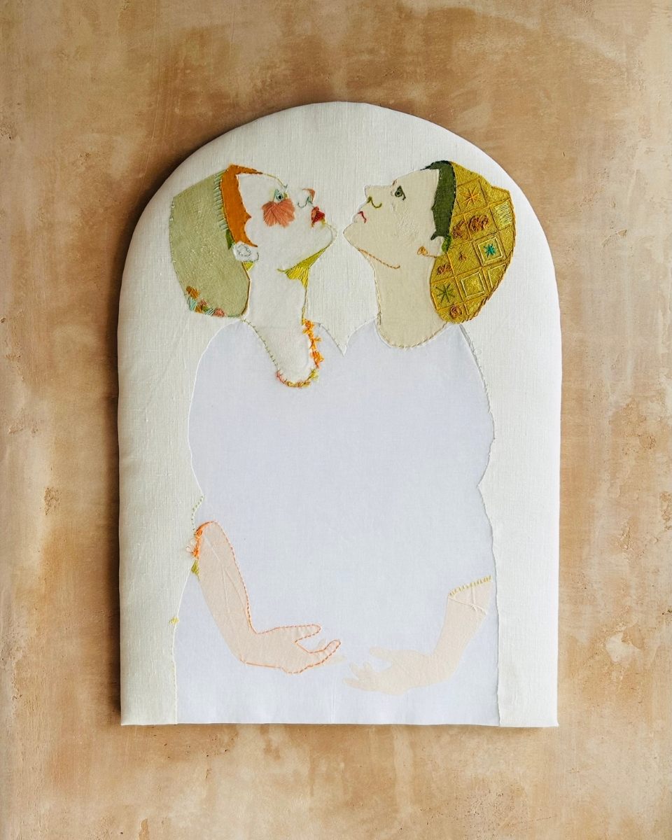 Close-up of Elizabeth Loveday’s embroidery artwork titled "Us," depicting a narrative scene of two women holding each other for Partnership Editions.