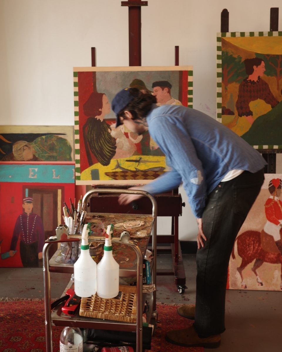 Elliott Pittam working at his studio easel next to a paint trolley, creating a new piece for Partnership Editions.