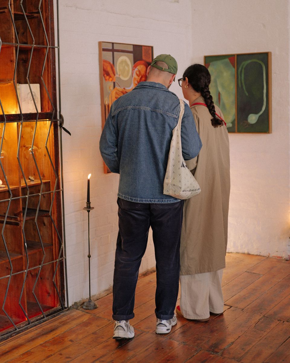 Gallery visitors reading artist biographies and exhibition notes at the Emblems show for Partnership Editions.