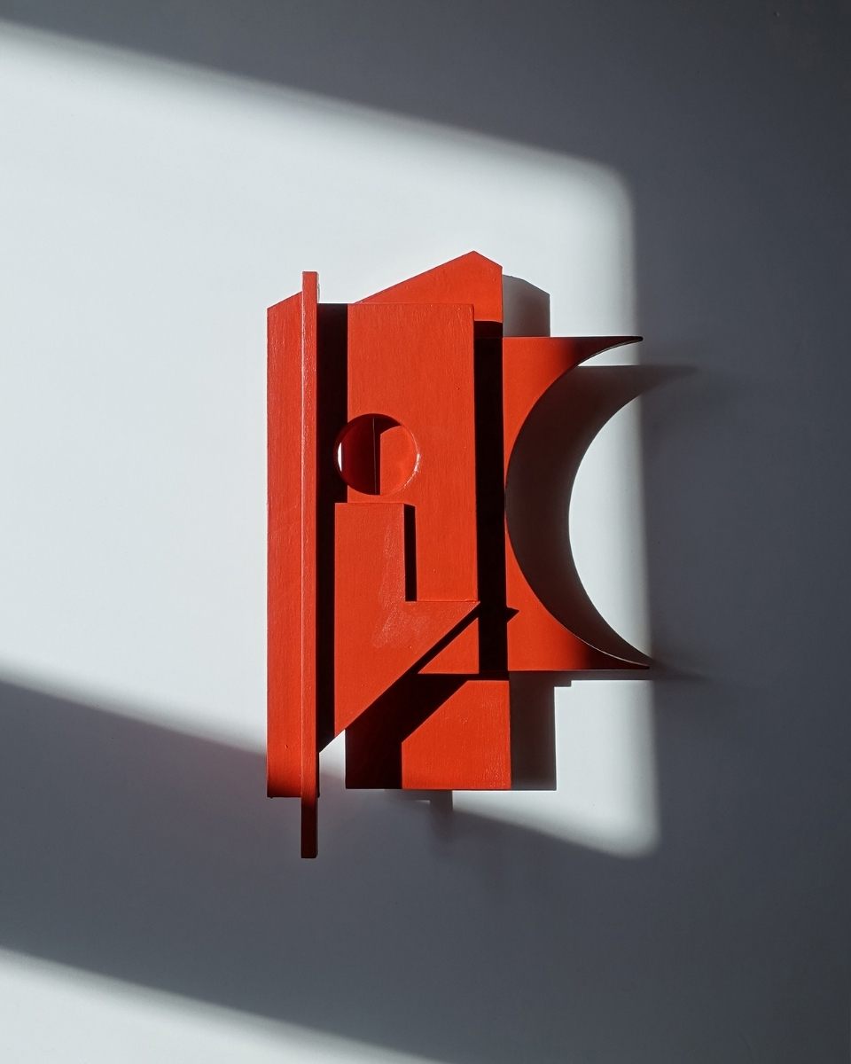 Carousel image of a red, architectural 3D sculptural assemblage piece by Emily Forgot, mounted on a wall for Partnership Editions.