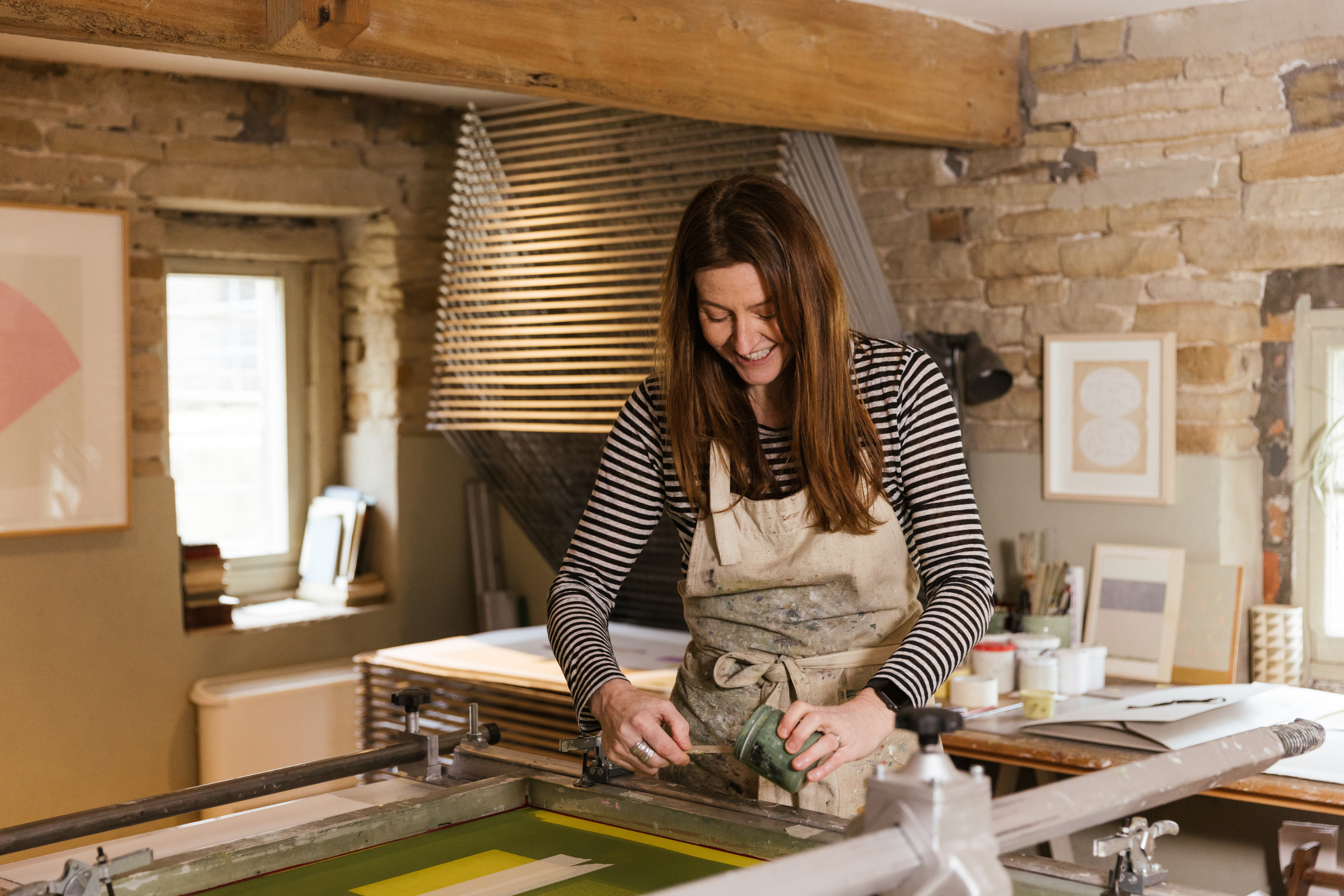 Main banner featuring award-winning printmaker Emma Lawrenson working on a screenprint inside her art studio.