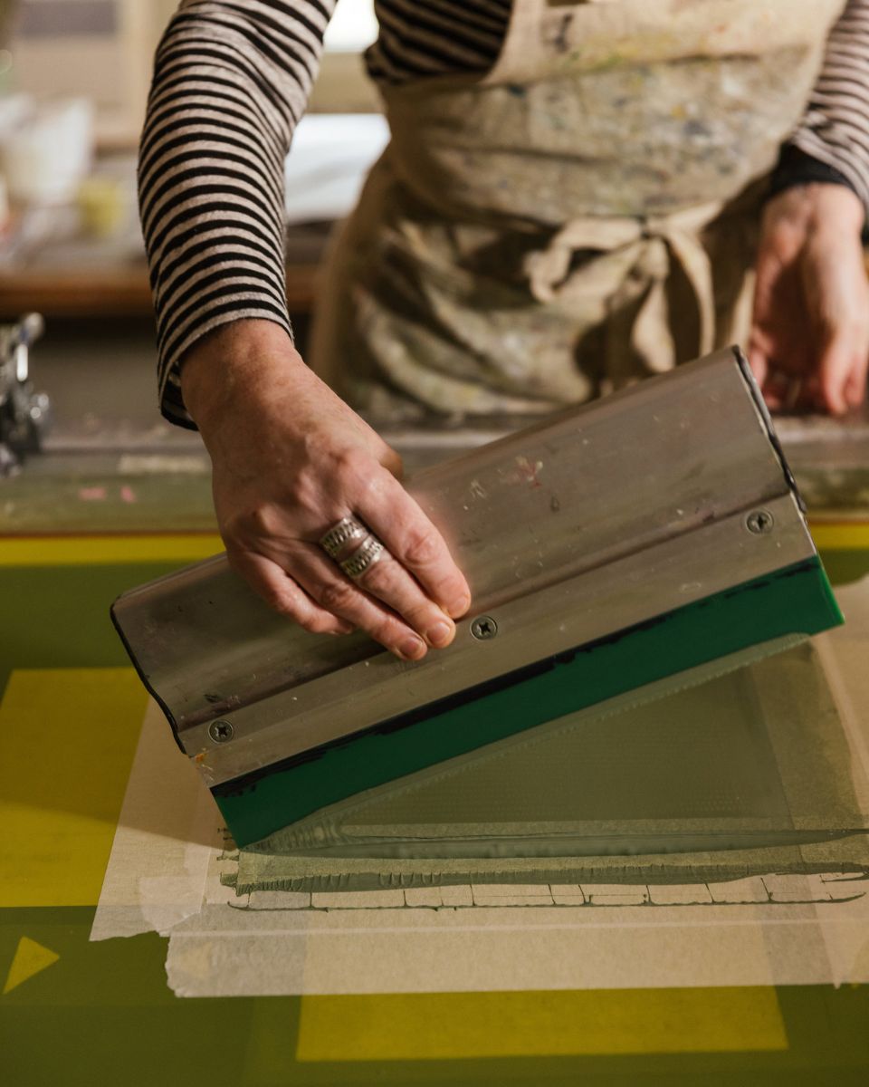 Close-up of artist Emma Lawrenson smoothing ink during the screenprinting process.