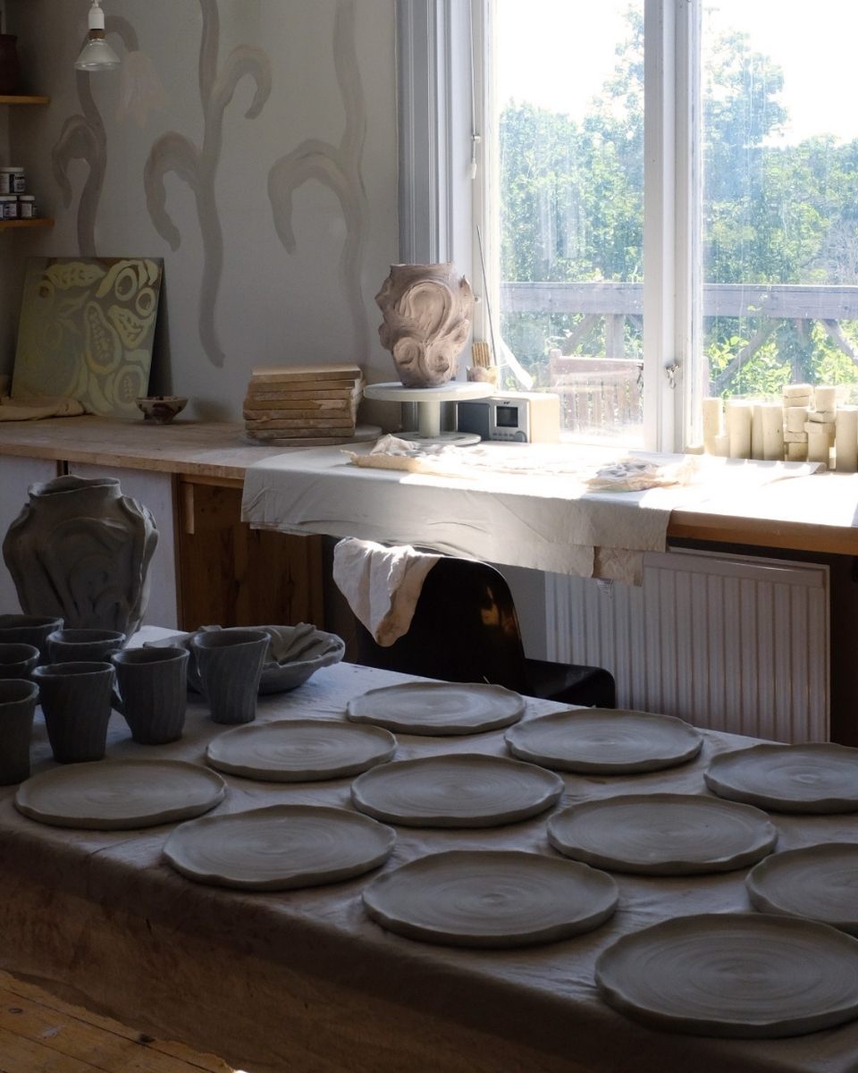 Detail shot of hand-sculpted clay works in progress, including relief plates and vases, in Fanny Schultz’s studio for Partnership Editions.