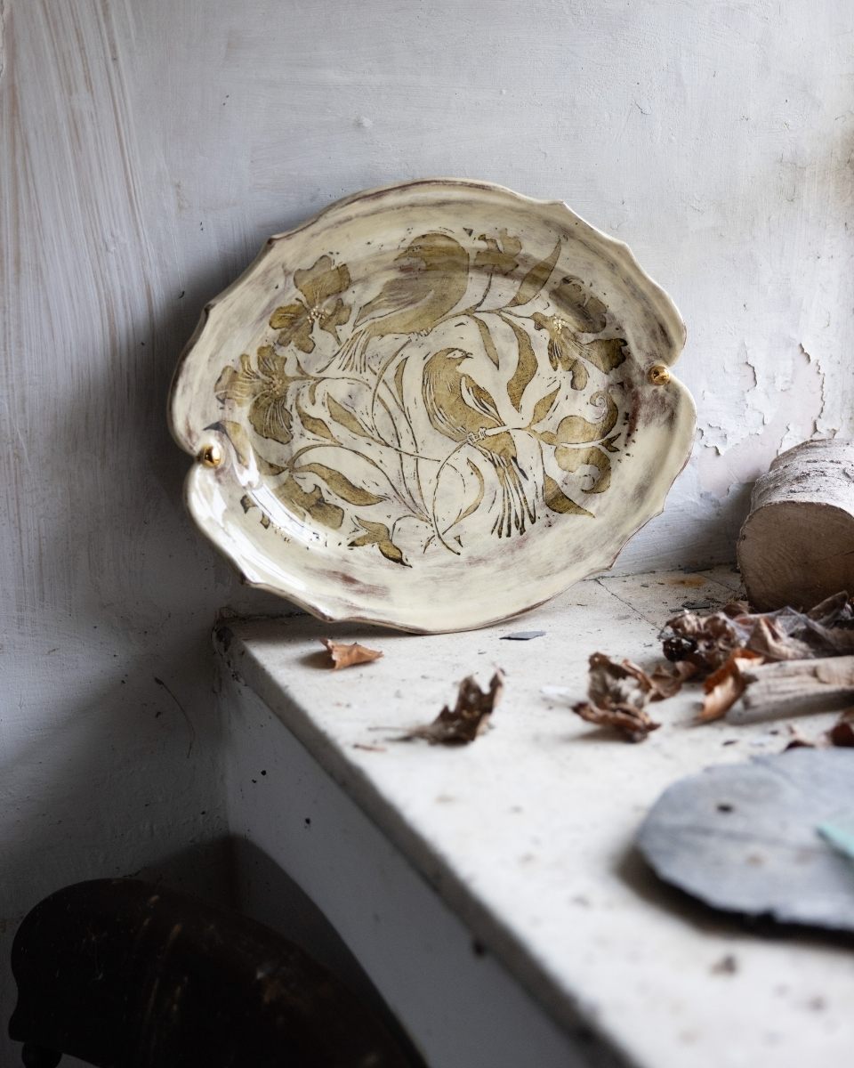 Professional shot of a decorative ceramic plate by Freyja Lee featuring an intricate bird and floral pattern for Partnership Editions.