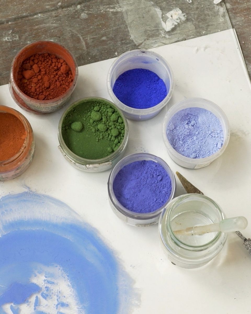 High-angle view of raw mineral pigments and natural materials used by Grace Crabtree in her artist studio for Partnership Editions.