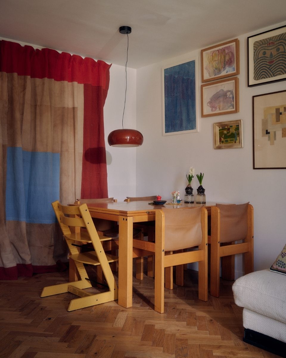 Room corner in Isabel Farchy’s  home studio, featuring a dining table and a hand-dyed textile curtain panel for Partnership Editions.