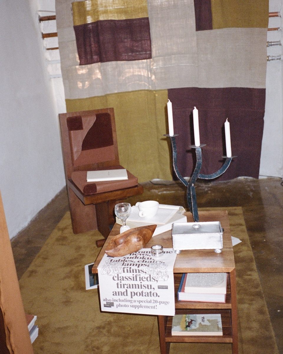 Styled interior shot featuring Isabel Farchy’s abstract textile panel displayed alongside wooden furniture for Partnership Editions.