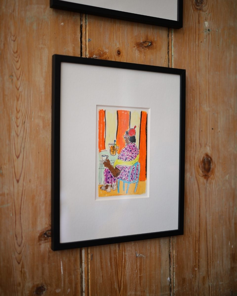 Close-up detail of a framed Isabella Cotier illustration mounted on a wooden wall at the Riverside Cafe.