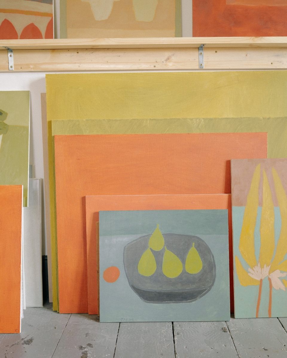 Close-up detail of artist Jay Harper’s muted oil paintings on wood panels leaning together in her studio.