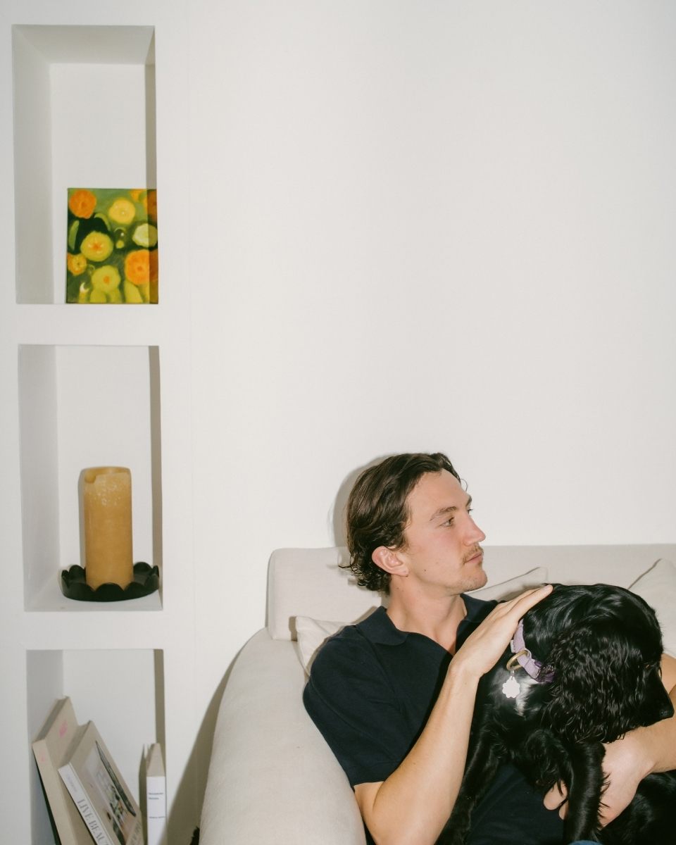 Personal portrait of Jesse Williams with his dog in his light-filled home studio, capturing his creative environment for Partnership Editions.