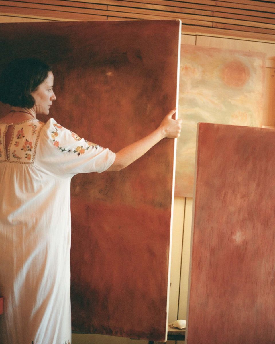 Artist Julianna Byrne moving a monumental, large-scale abstract landscape painting inside her studio.