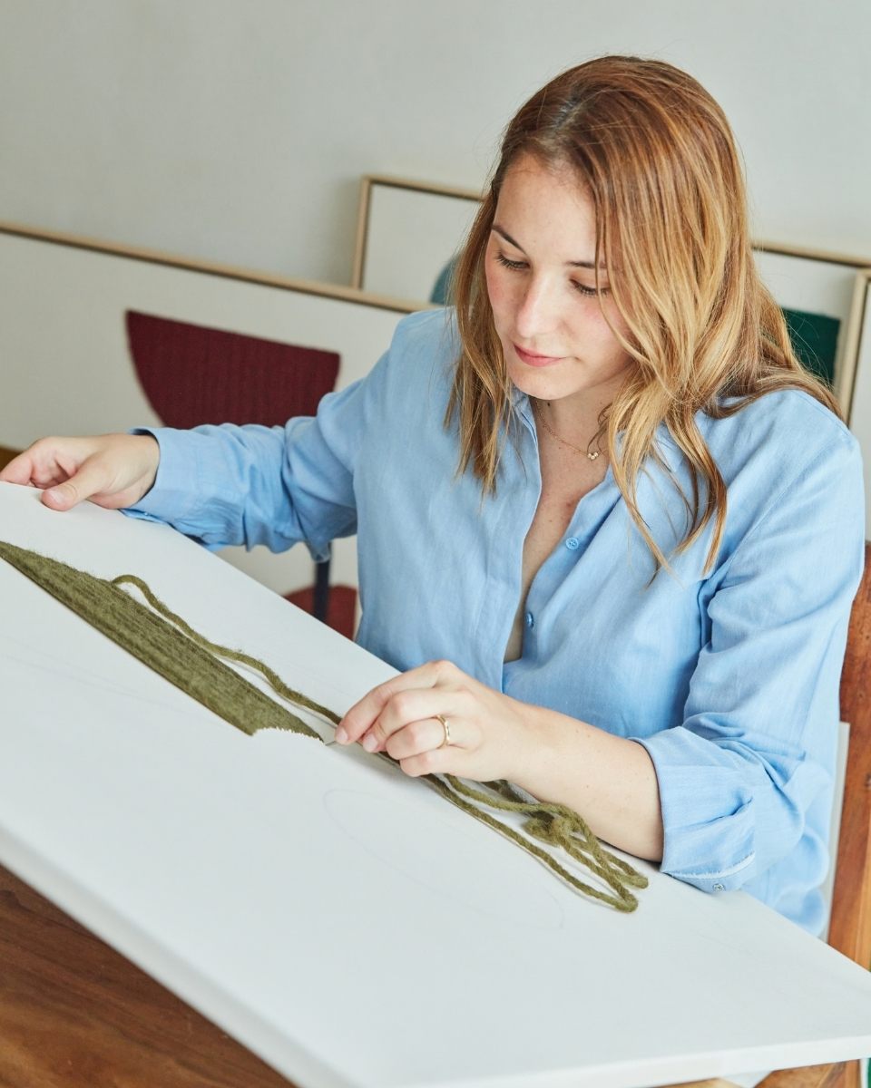 Close-up of Kanica’s hands meticulously weaving ethically sourced jute and cotton yarns into a rhythmic composition for Partnership Editions.