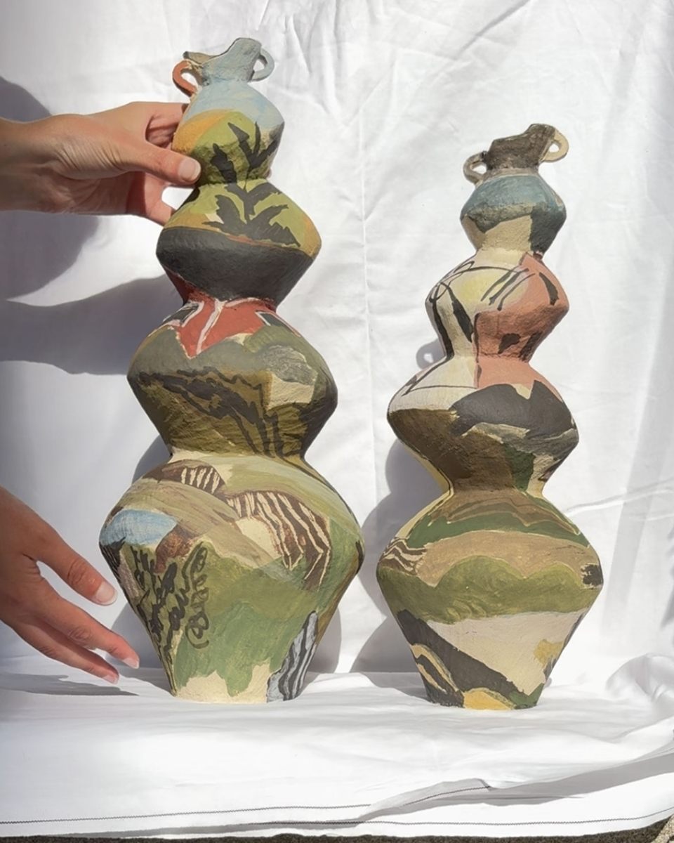 Katie Moore arranging her hand-painted ceramic sculptures on soft fabric for a professional shoot for Partnership Editions.