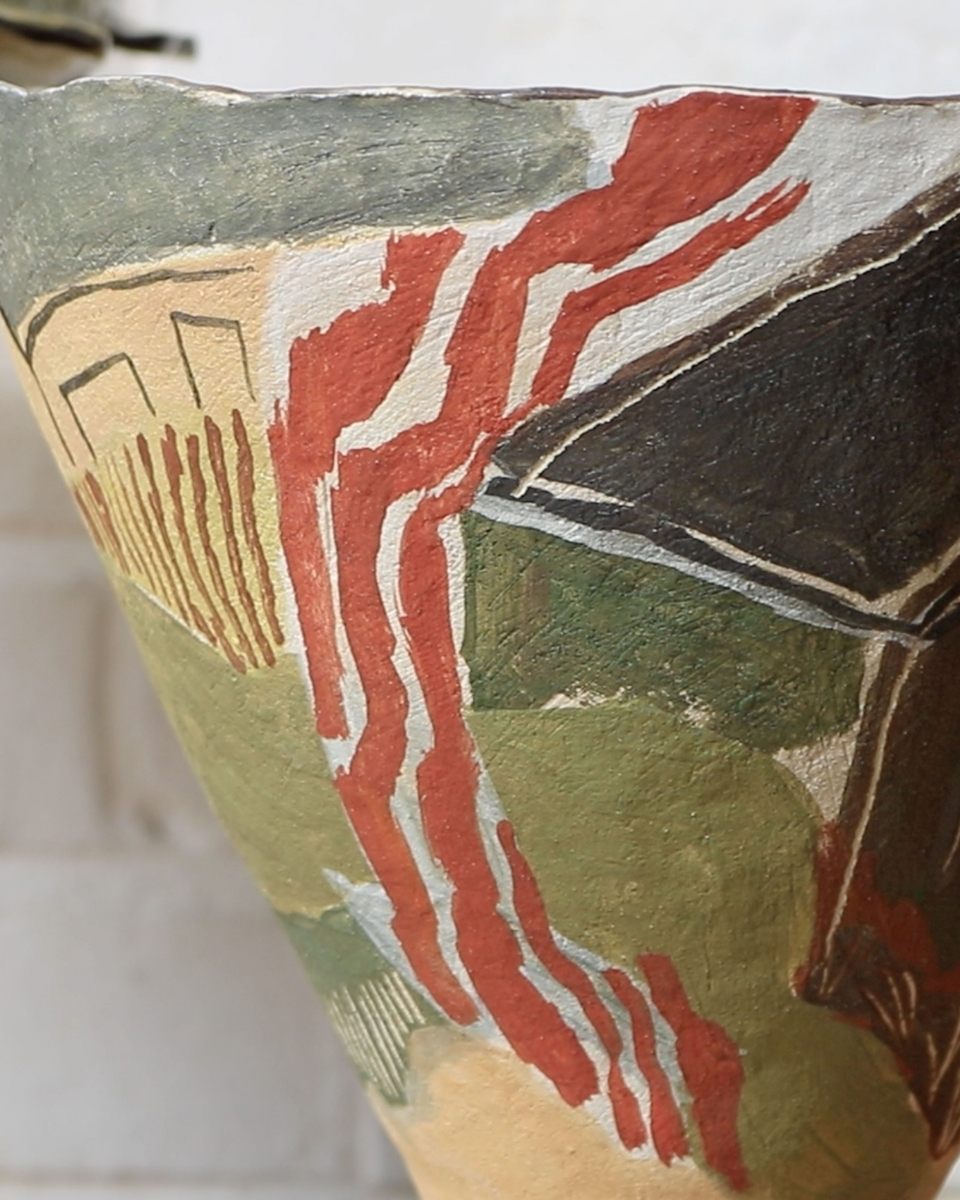 Close-up of a hand-painted ceramic relief by Katie Moore, showcasing her signature use of pigments and organic, textured forms.