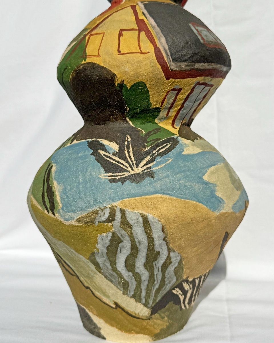 Close-up detail of a colorful, hand-built ceramic vase painted with a landscape scene by Katie Moore.