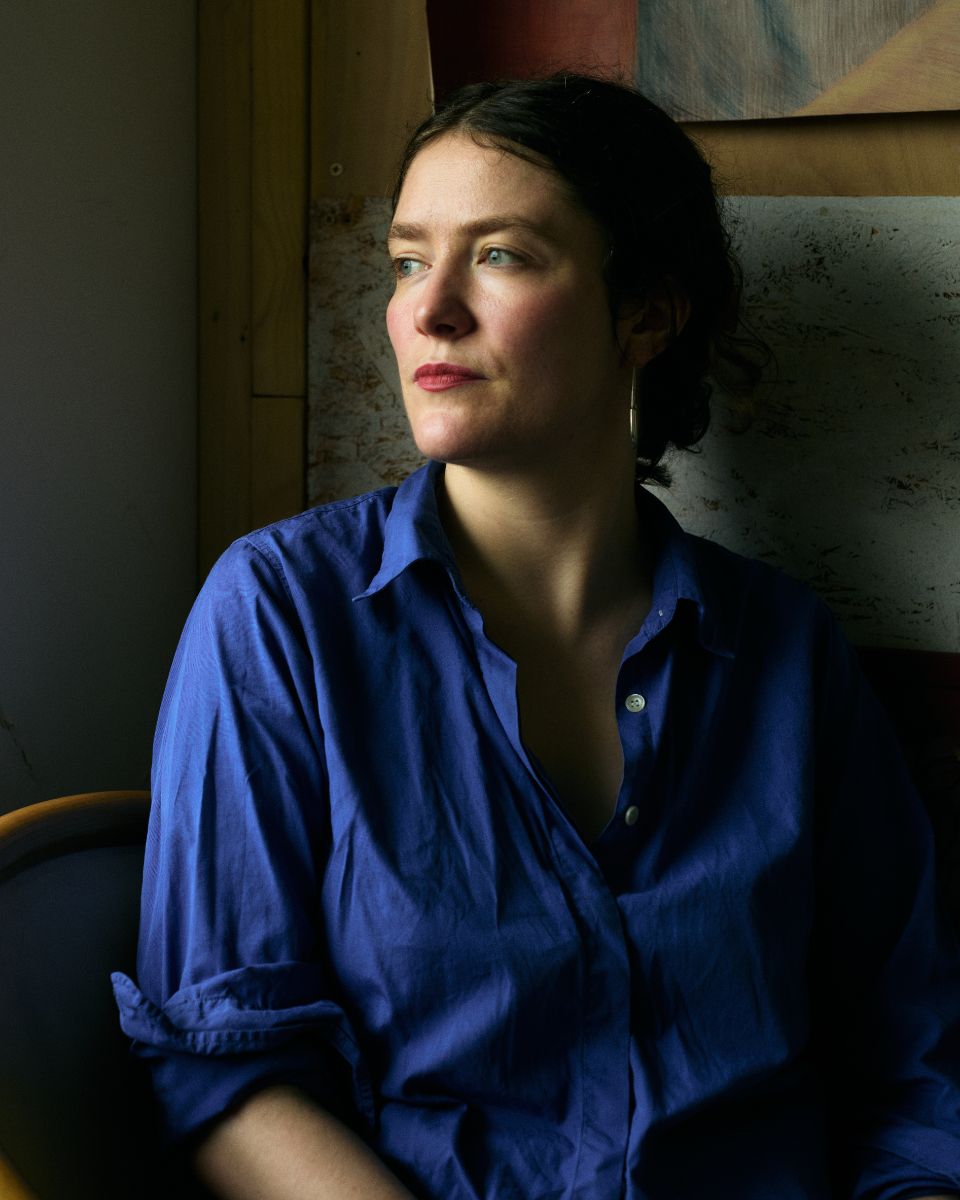 Studio portrait of artist Keziah Mornin staring thoughtfully into a soft, directional beam of natural light.