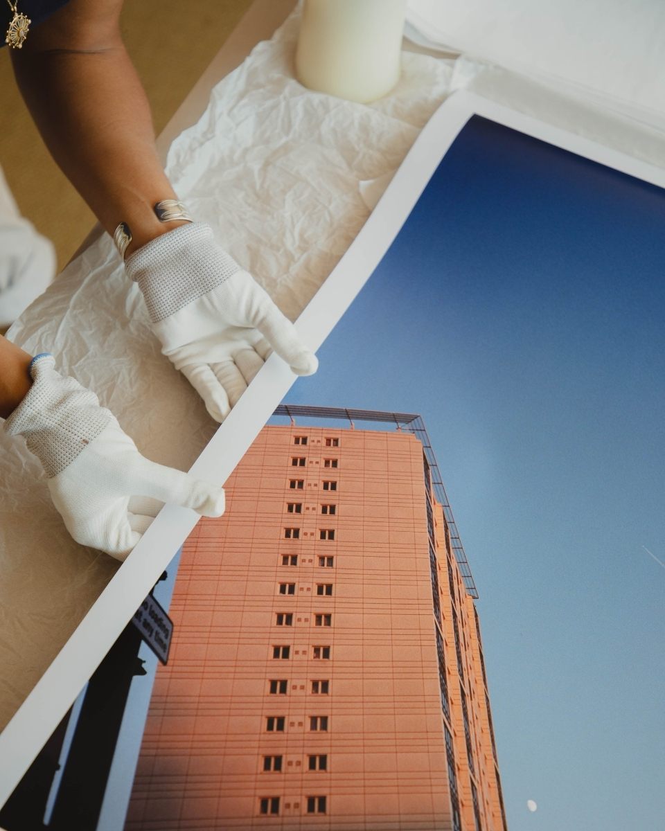 Close-up of Lily Bertrand-Webb’s hands handling a limited edition film print, highlighting the unique textures and marks of hand-printing.