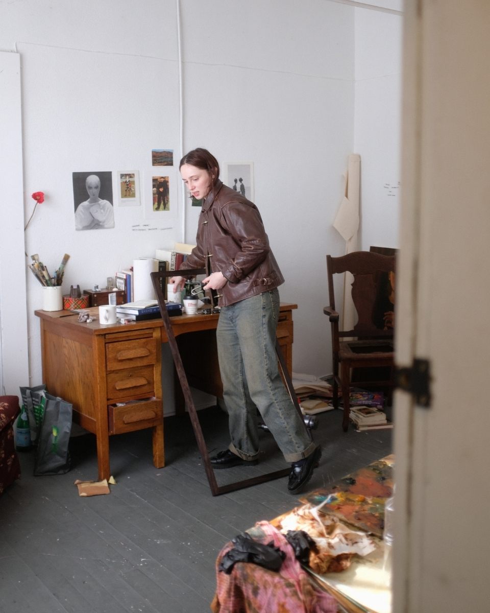 Full-length studio portrait of Lily Rose Fine in her London studio, surrounded by found photography that inspires her Partnership Editions collections.