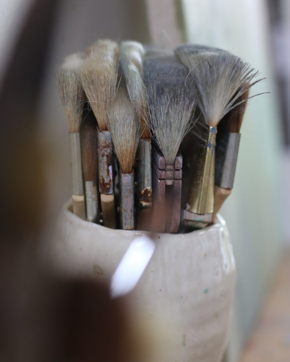 Close-up of a jar of well-used paintbrushes in Lisa Hardy’s studio, the tools used for her signature minimalist mark-making.