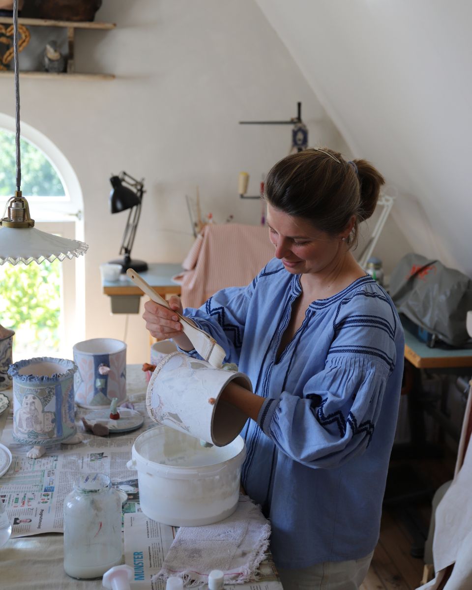 Lisa Sandner working in her studio painting on a ceramic vase for the On Believing Collection at Partnership Editions.