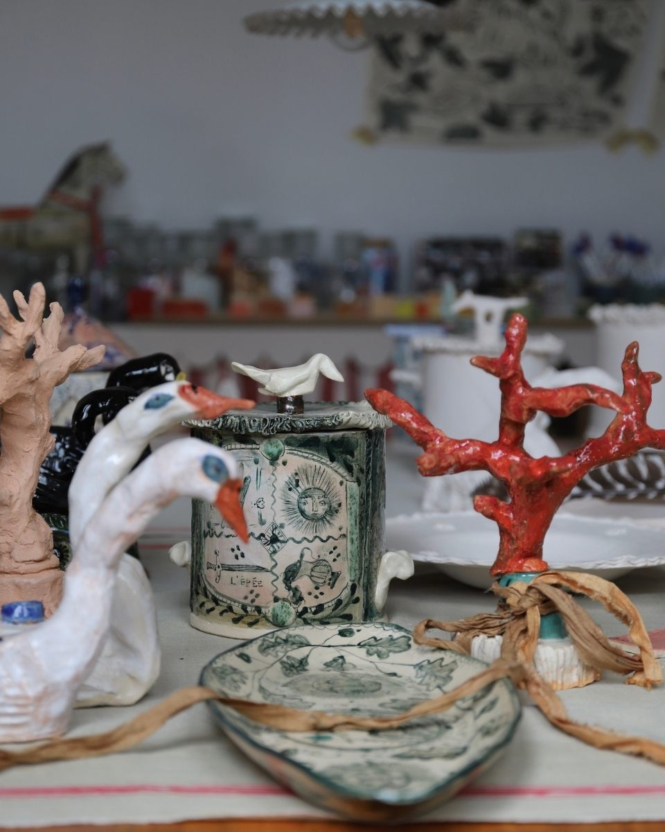 A collection of finished and work-in-progress sculptural ceramics by Lisa Sandner displayed on her studio workbench.