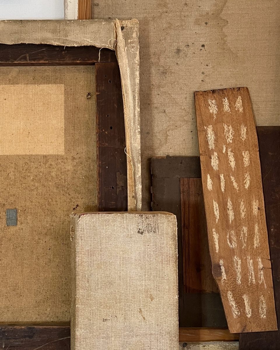 Detail of raw wooden planks and canvas frames in Lucy Naughton’s studio, highlighting the architectural materials of her practice.