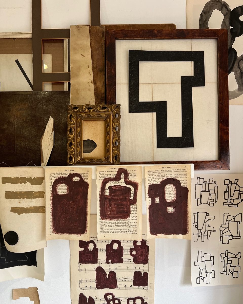 Close-up of Lucy Naughton’s studio wall featuring a curation of minimalist framed artworks and experimental sketches for Partnership Editions.