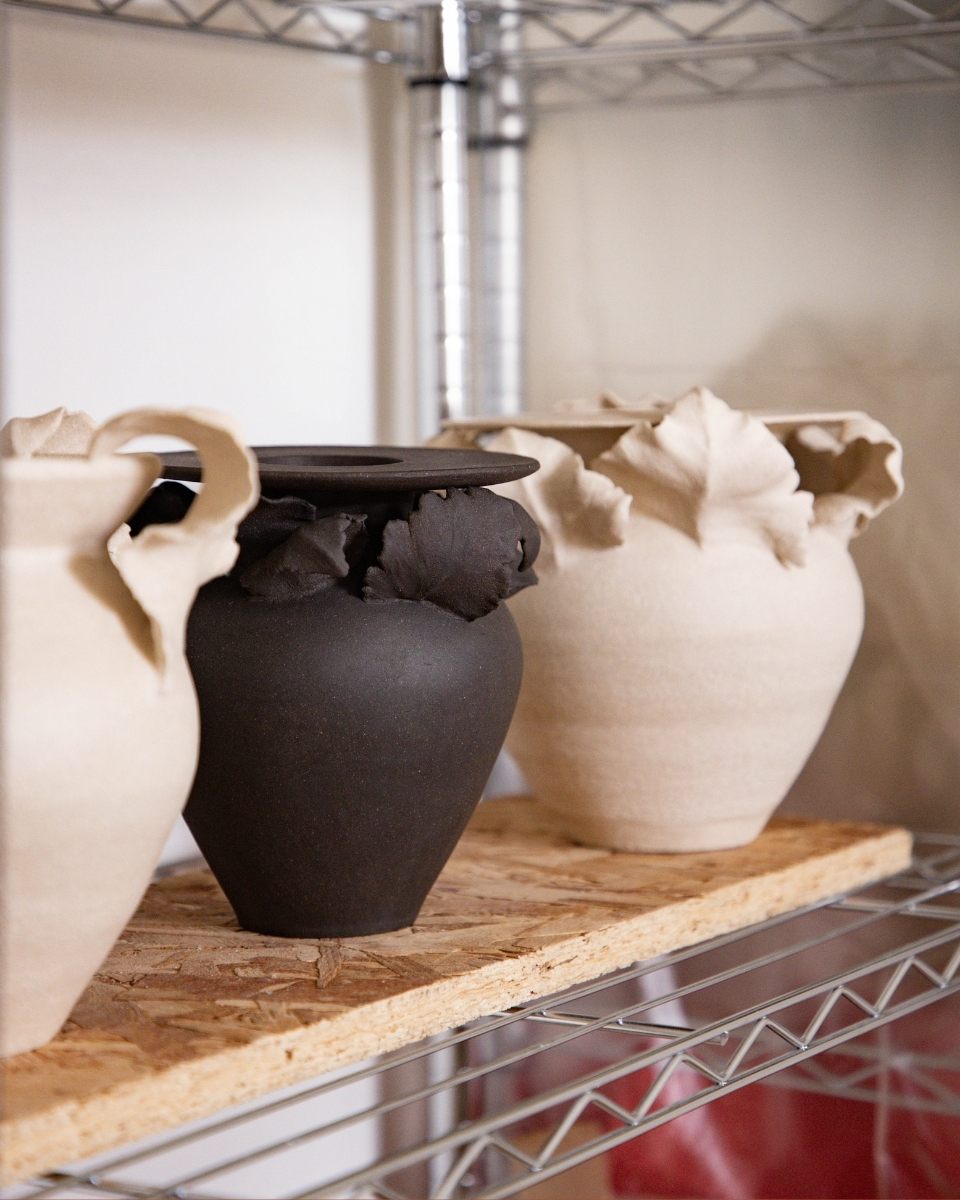 Collection of finished black and white stoneware vases by Lucy Whitford displayed on a studio shelf, featuring her signature organic silhouettes.