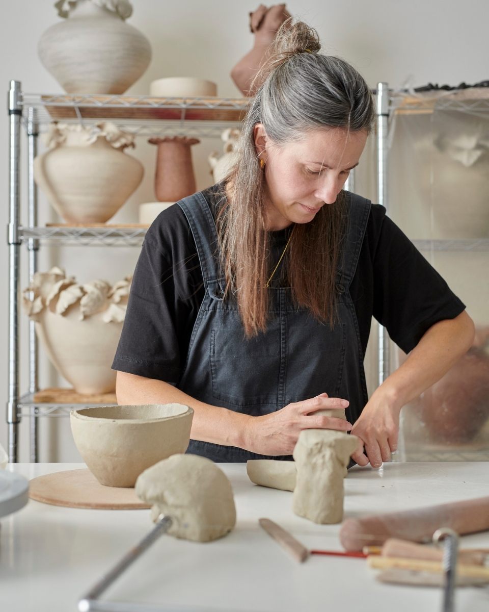 Artist Lucy Whitford handling raw clay during the initial making stage of a hand-built vessel.