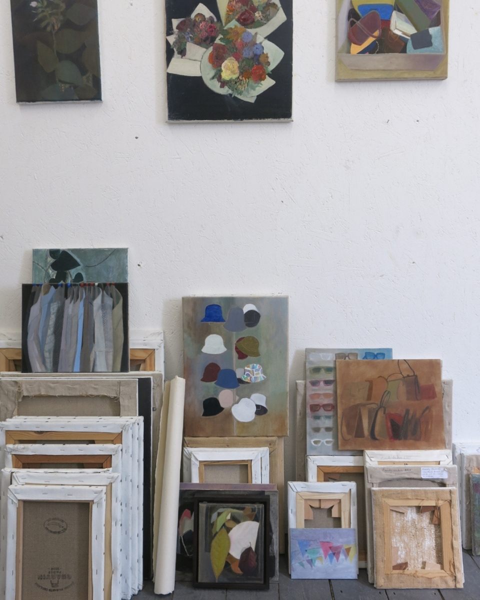 A curated wall shot of Mandy Hudson’s studio featuring a series of unframed, mounted, and unmounted paintings on paper and canvas.