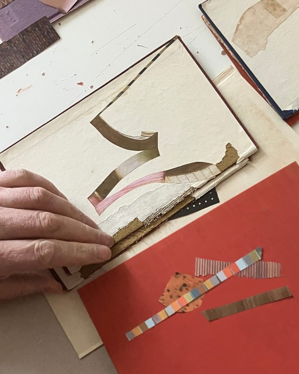 Close-up of Matthew Richardson’s hands delicately assembling paper fragments into a cohesive abstract composition.