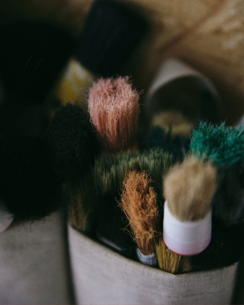 Very close-up of Max Freund’s well-worn paintbrushes in his Vienna studio, highlighting the tools behind his textured, narrative-led painting style.