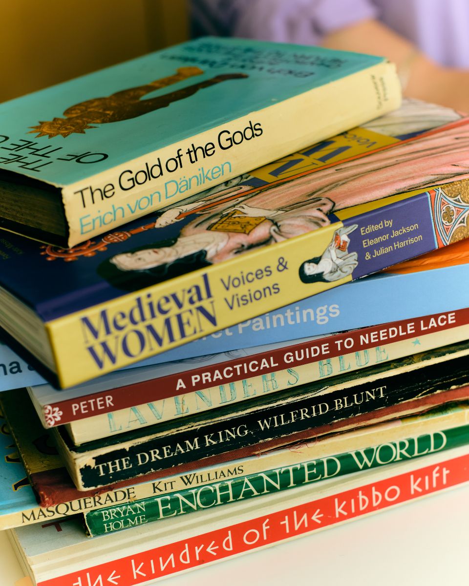 A curated selection of art and textile reference books stacked inside Molly Lester's studio.
