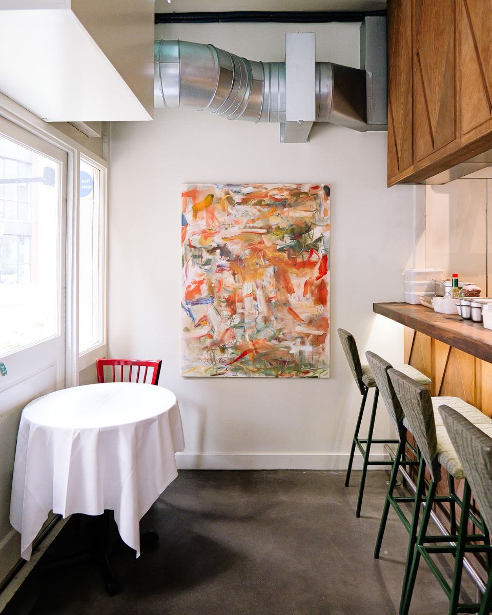 Maarten van den Bos’ vibrant painting mounted on the wall at Bistro Freddie’s for the Open Call Winners Collection 2024.
