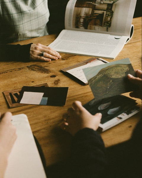 Partnership Editions team hands sifting through physical artist prints for the dedicated art advisory section.