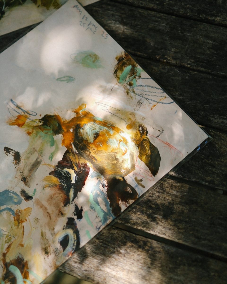 A small-scale Philip Maltman abstract landscape painting lit by dappled sunlight shining through trees.